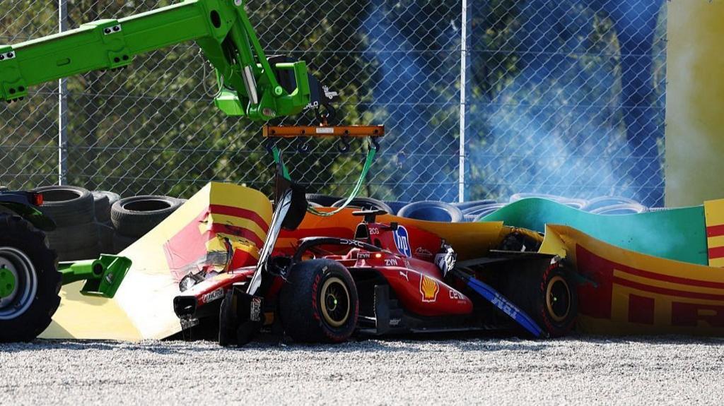 A crane prepares to remove the Ferrari of Charles Leclerc after his heavy crash into the barriers at the Parabolica corner during the Italian Grand Prix
