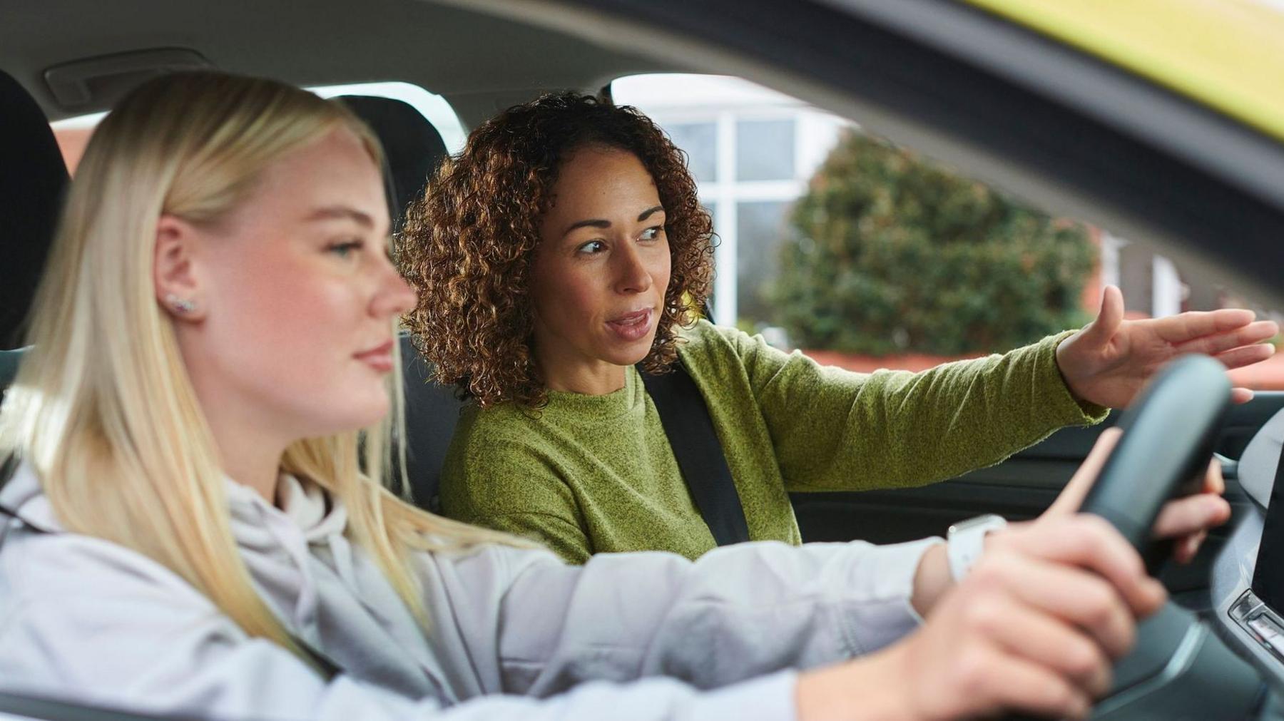 A learner driver and her instructor in a car