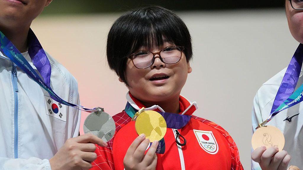 Yuki Kurihara is presented with a gold medal after winning Puyo Puyo gold at the Asian Games
