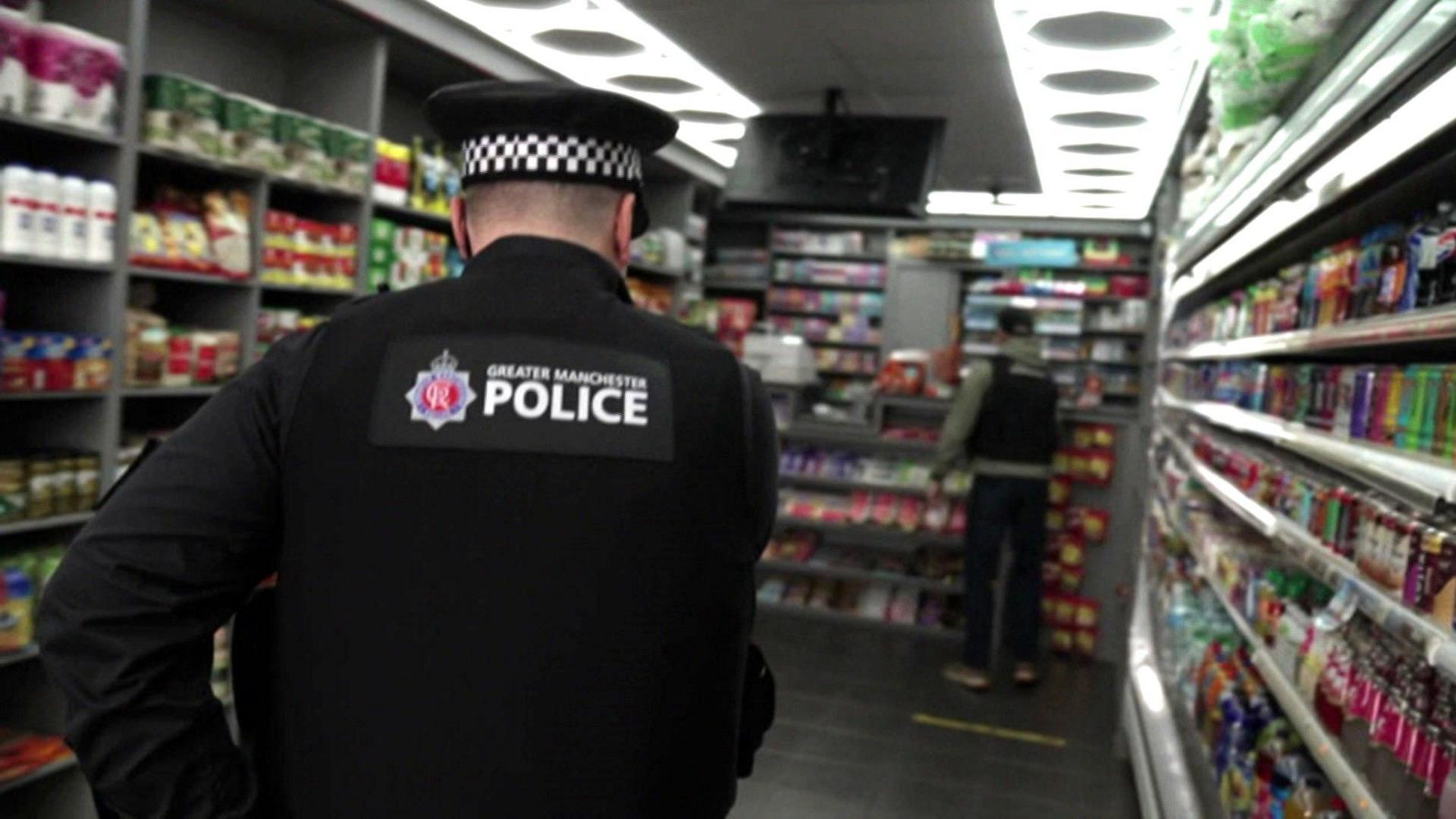 Police officer raiding shop in Greater Manchester area in July 2025