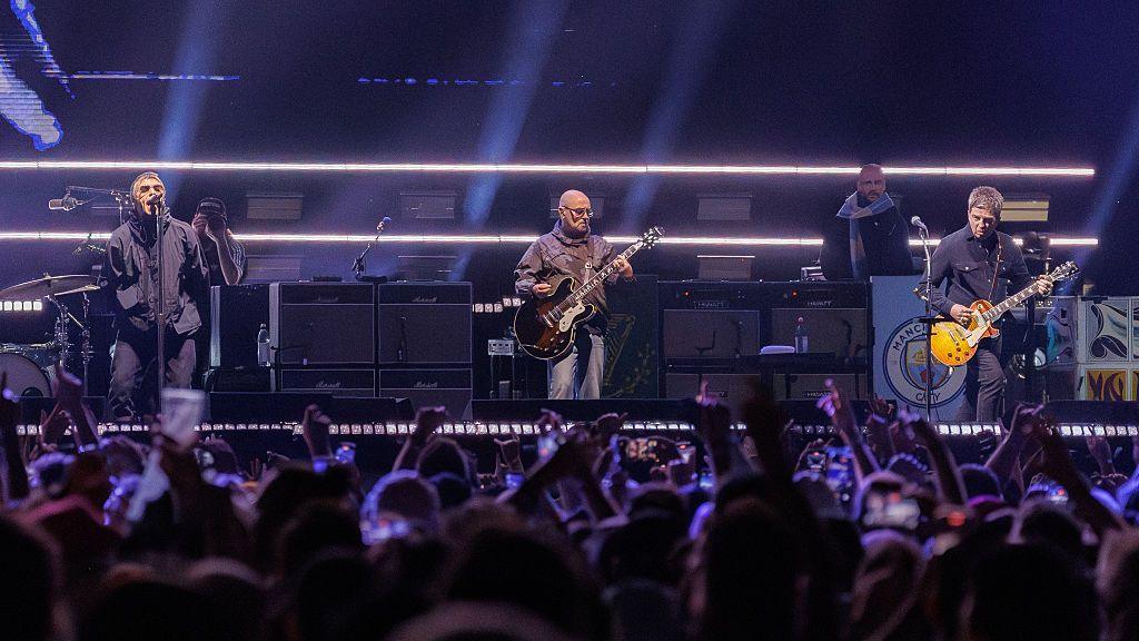 Oasis tour photo, with the band on stage performing