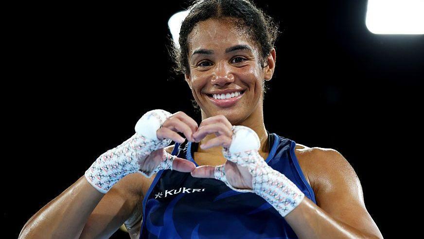 Chantelle Reid makes a heart symbol with her gloves off after winning a boxing match