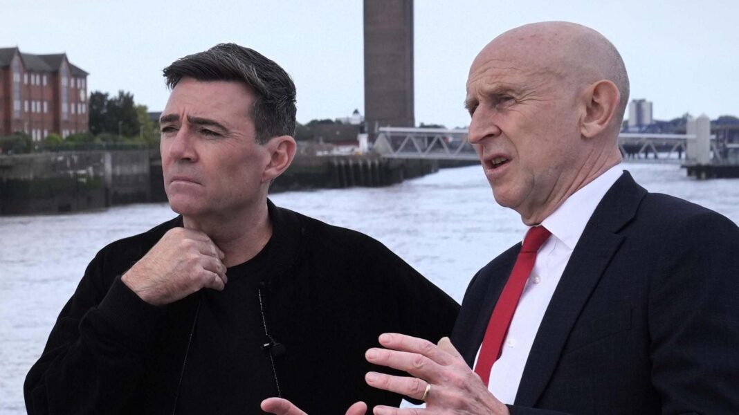 John Healey makes a point with his hands to a thoughtful looking Andy Burnham, who is gazing out across the Mersey river on a ferry in Liverpool