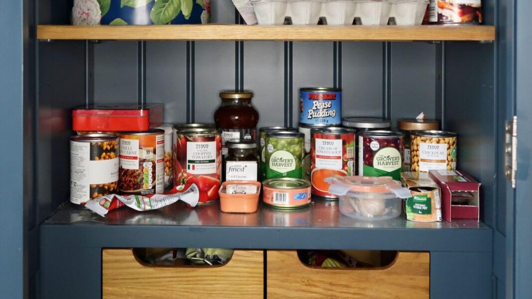 A cupboard filled with jars and tins of food.