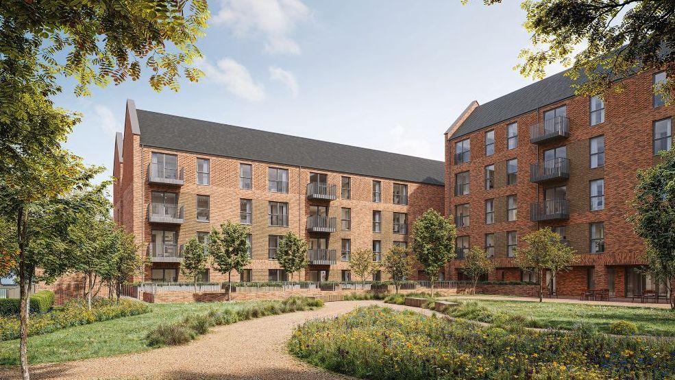 A computer generated image of a grassy courtyard outside a new-build block of apartments. They're made with red brick and have large windows and balconies.