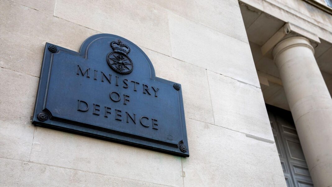 A black plaque reading 'ministry of defence' on the white external wall of a building.