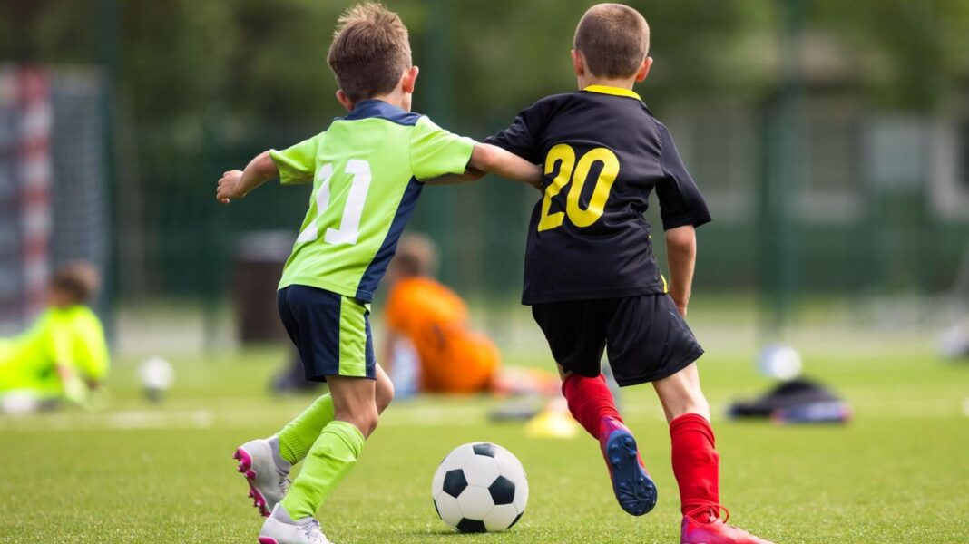 SFA propose youth quotas along with financial incentives Two young boys wearing football kits playing football. One in a green kit has his arm outstretching touching the other boy who is in a black kit. There is a black and white ball in front of them.