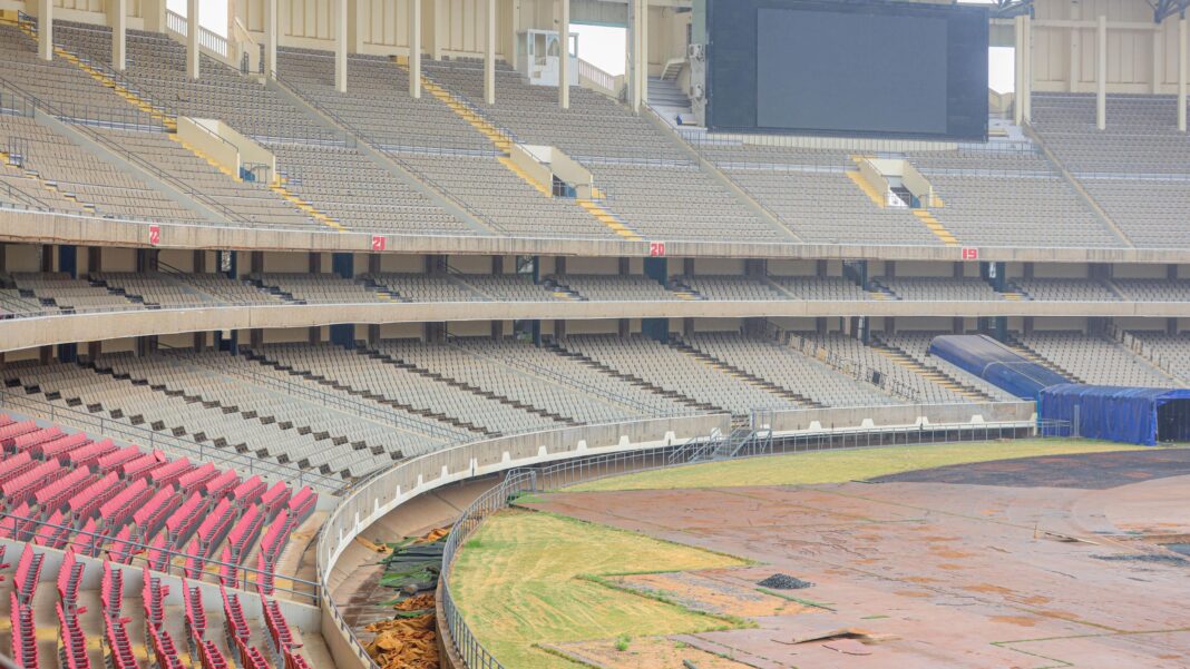 Postponement not an option as Kenya races to be ready for Afcon 2027 The Kasarani Stadium under renovation, showing a vast three-tier stand with only one section of seating and a bare field