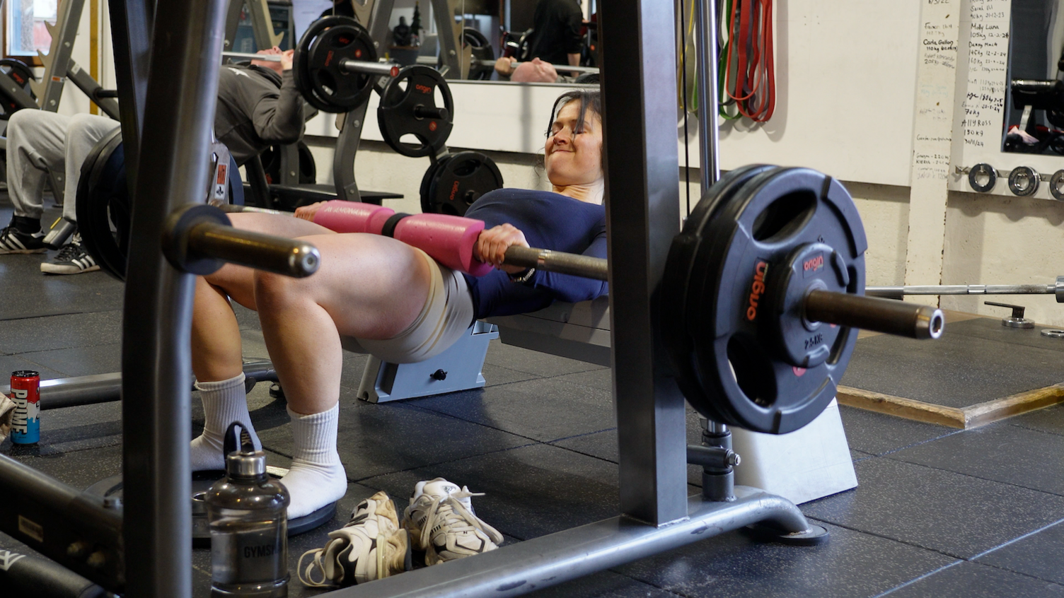 Sarah Mackay is pictured doing hip thrusts with a barbell in the gym.