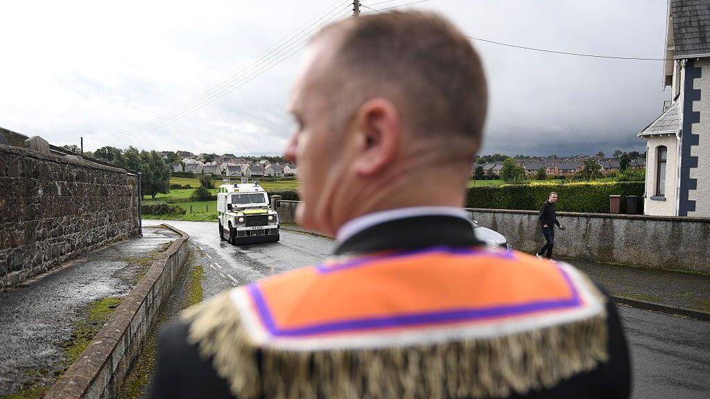 A member of the Orange Order stands outside Drumcree Church on September