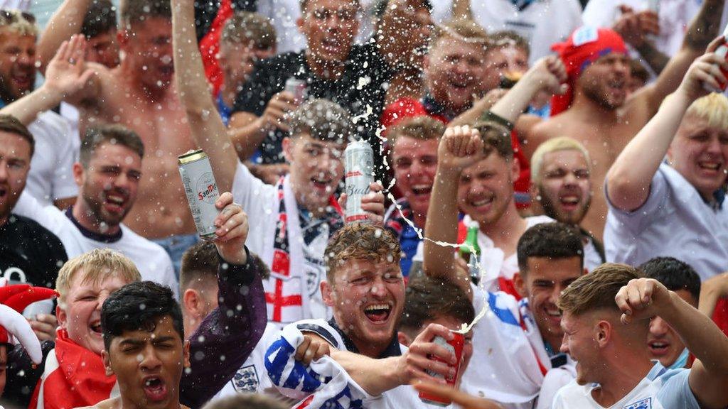 Football fans celebrate with beer in the air
