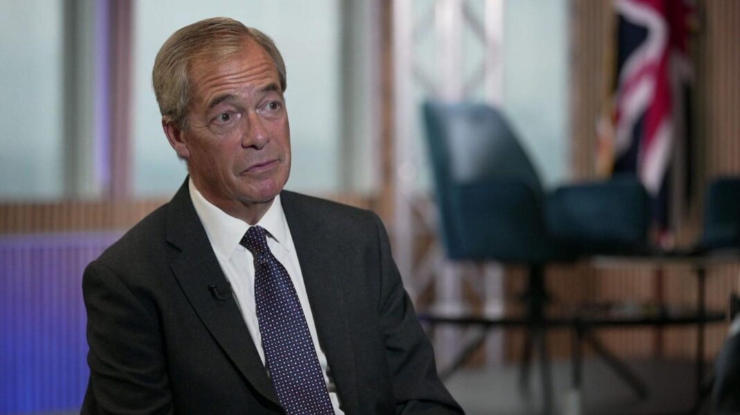 Nigel Farage wearing a dark suit and a dark blue tie with small white dots