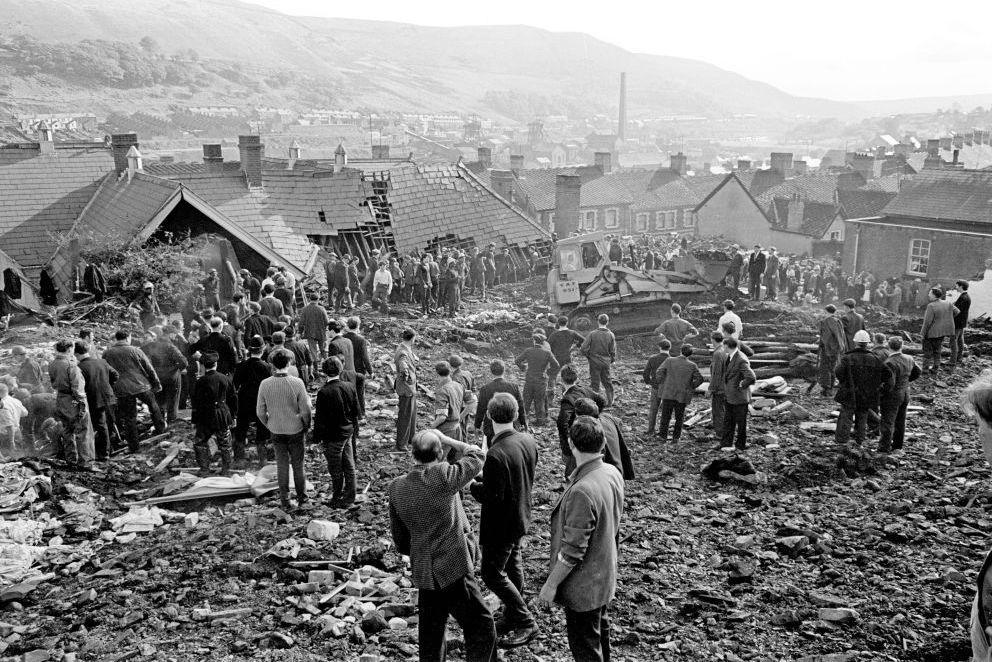 Rescue workers stand and survey the damage to the ruined junior school in Aberfan