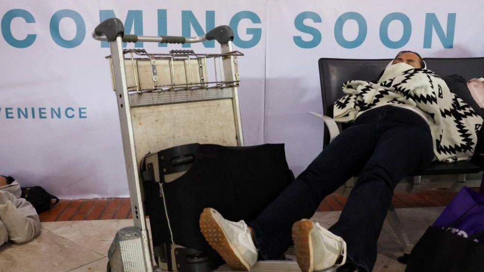 Stranded passengers rest as Soekarno Hatta International Airport closed its operations