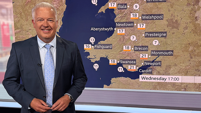 Derek in front of weather map in studio