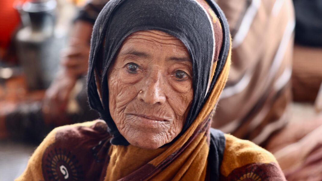 An old woman wearing black and brown garments
