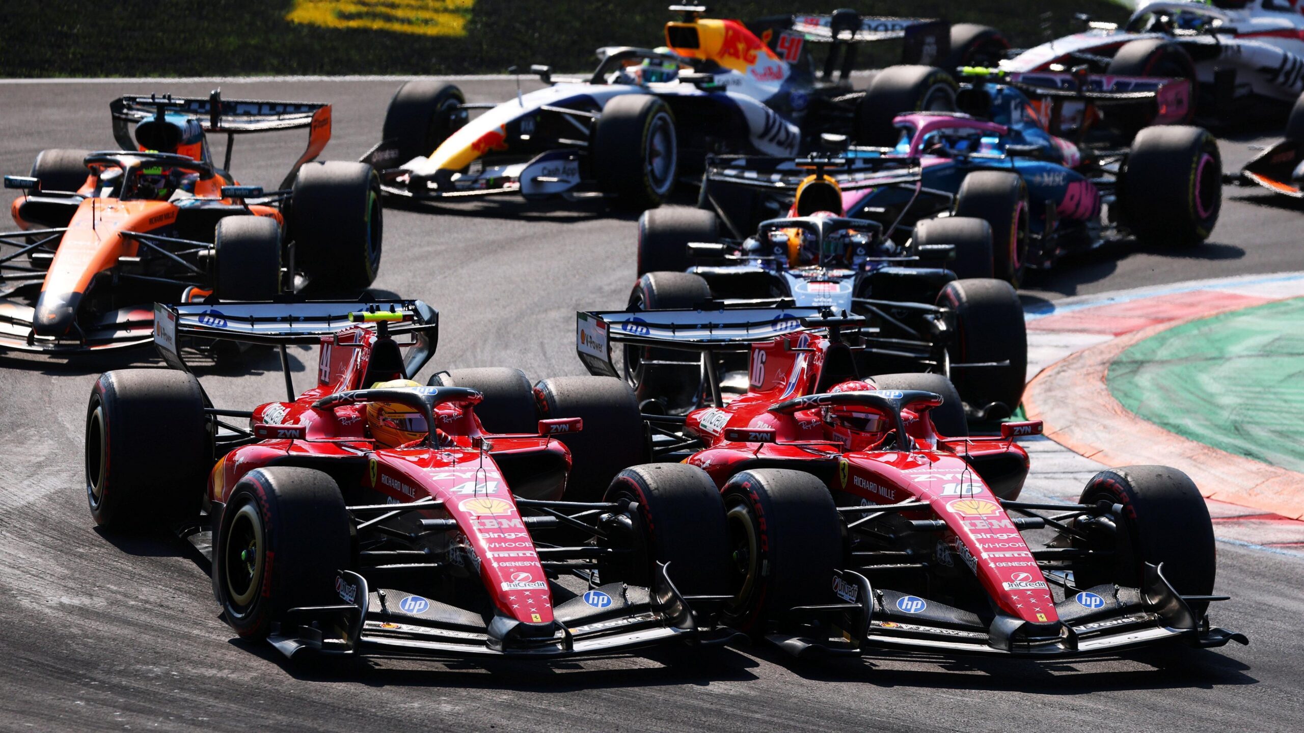 The Ferraris of Charles Leclerc and Lewis Hamilton side by side into the first chicane at the start of the Italian Grand Prix