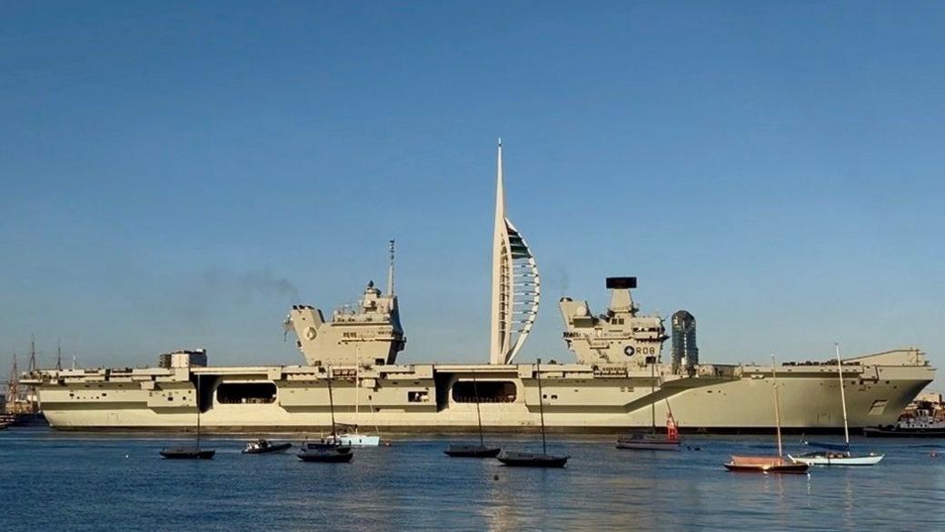 HMS Queen Elizabeth setting off along the water in Portsmouth.