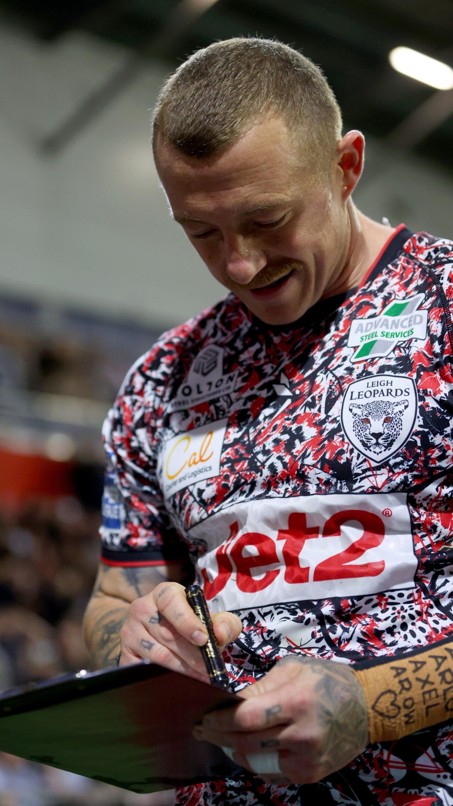 Josh Charnley signs a mock contract while celebrating a try