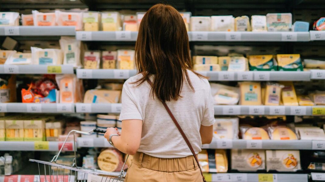 Aldi boss says some of rivals’ loyalty discounts ‘dupe’ customers A woman from behind holding a shopping basket while looking at the cheeses on offer in a supermarket