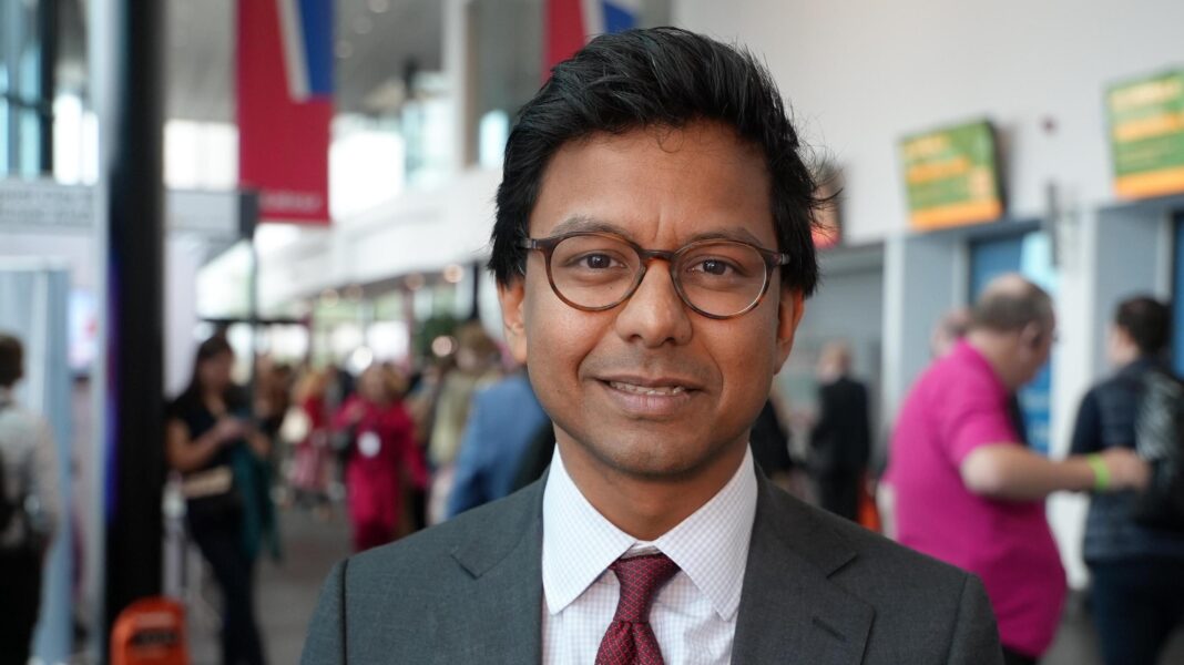 UK needs plan in case of ‘unprecedented’ AI job losses, says minister Kanishka Narayan, wearning dark rimmed glasses and a suit and tie, poses for the camera at a party conference