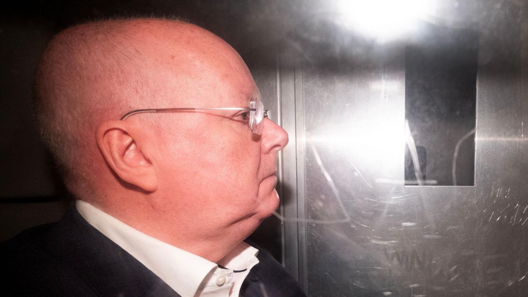 Former SNP chief executive Peter Murrell leaving in a prison van from the High Court in Edinburg after sentencing. It is a side view of Peter Murrell who looks straight ahead. He is bald and wears glasses as well as a white shirt and black blazer.
