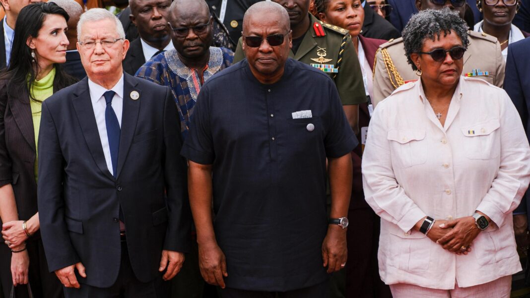 Ghana's President John Dramani Mahama, Barbados' Prime Minister Mia Amor Mottley and other dignitaries stand looking solemn.