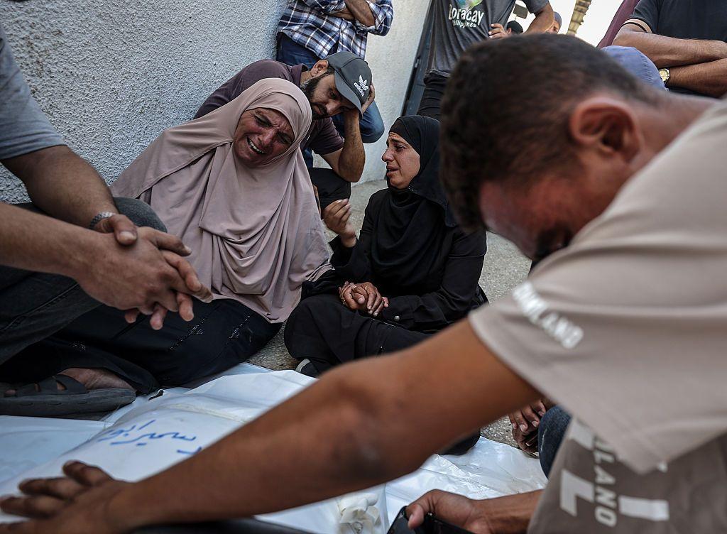 Palestinians seen crying over bodies of people killed in an Israeli attack targeting a beachfront cafe in Gaza City