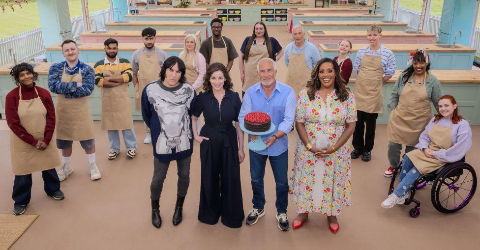 The new contestants standing with the judges in The Great British Bake Off tent