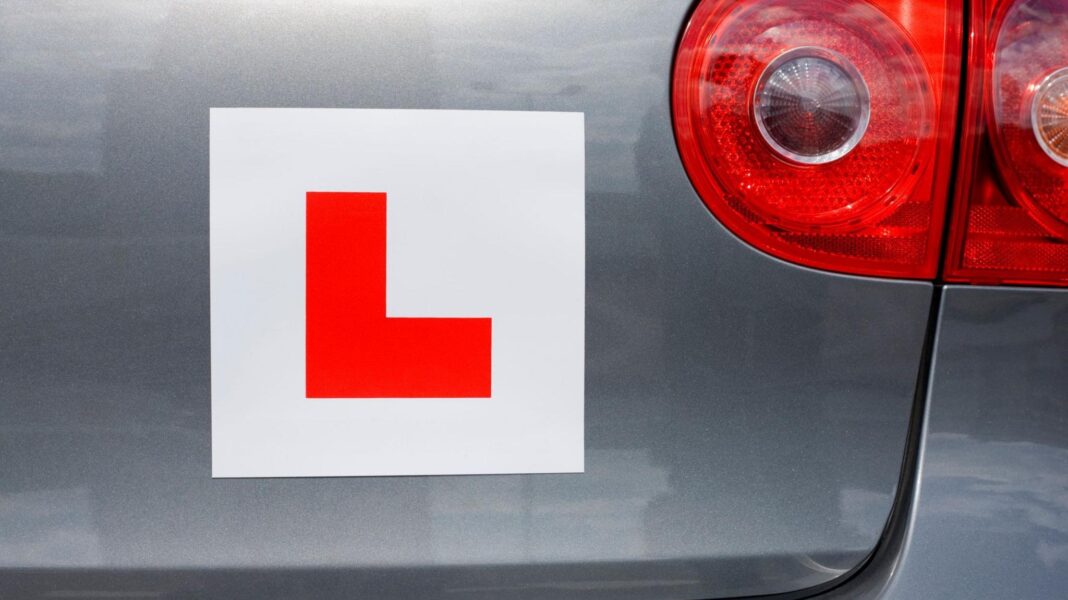 An L-plate, to demonstrate that someone is a learner driver, stuck to the boot of a silver car