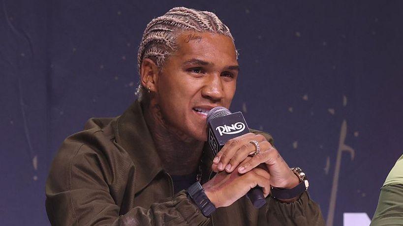 Conor Benn speaks into a microphone at a news conference