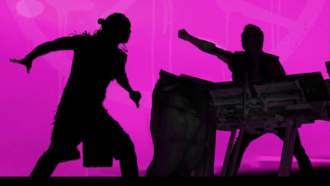 Members of the Prodigy performing on stage. They are dancing against a pink backdrop.