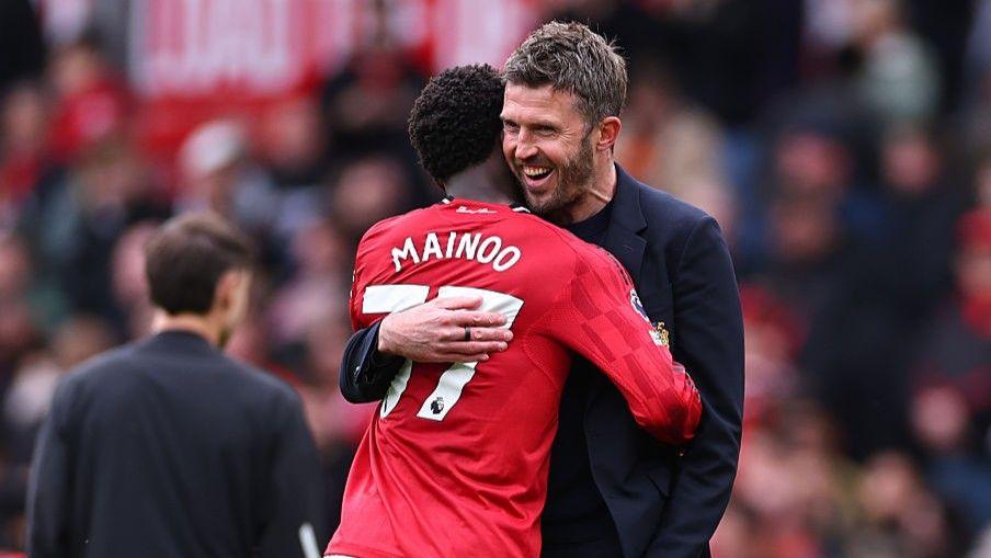 Manchester United head coach Michael Carrick with midfielder Kobbie Mainoo