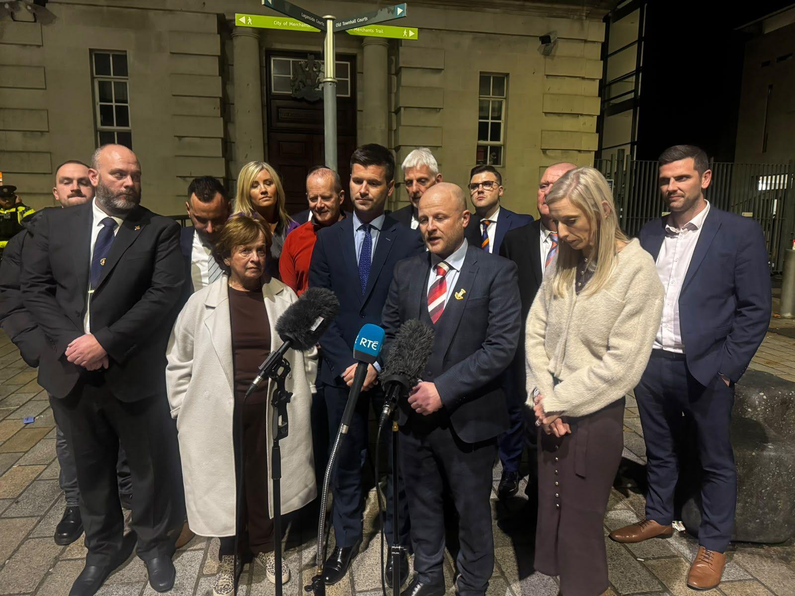 A group of people stand outside a courthouse in Belfast and include DUP MP Carla Lockhart and loyalist activist Jamie Bryson