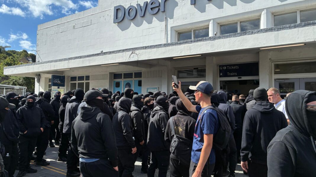 Disruption at Port of Dover as masked ‘stop the boats’ protesters block roads A large group of men dressed in black and wearing face coverings. They are congregating at the entrance to Dover Priory railway station.