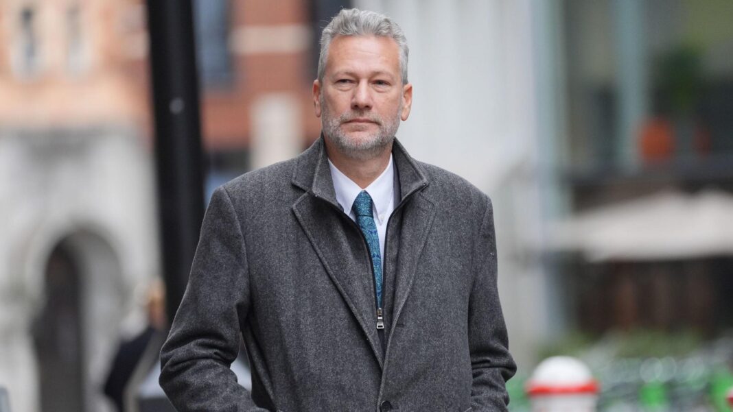 Disgraced ex-Reform Wales leader who took pro-Russian bribes must pay £22k Nathan Gill is wearing a grey coat, a blue tie and a white shirt in a street, with the street in the background out of focus