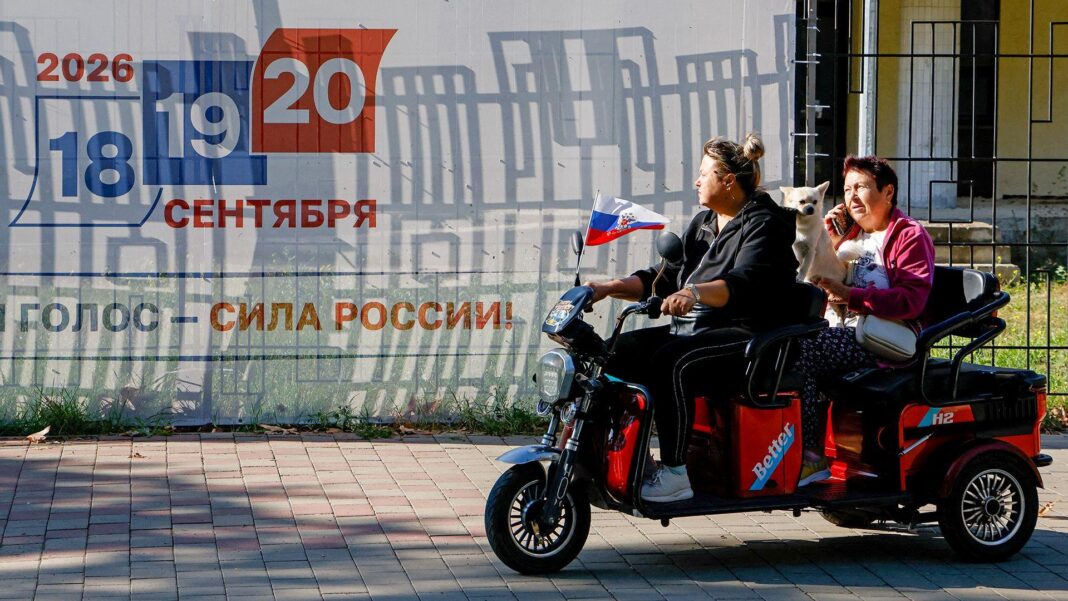 Trump signs sweeping Russia sanctions bill Two people ride an electric motorcycle along a street in front of a billboard advertising the upcoming elections, in Crimea on Tuesday.