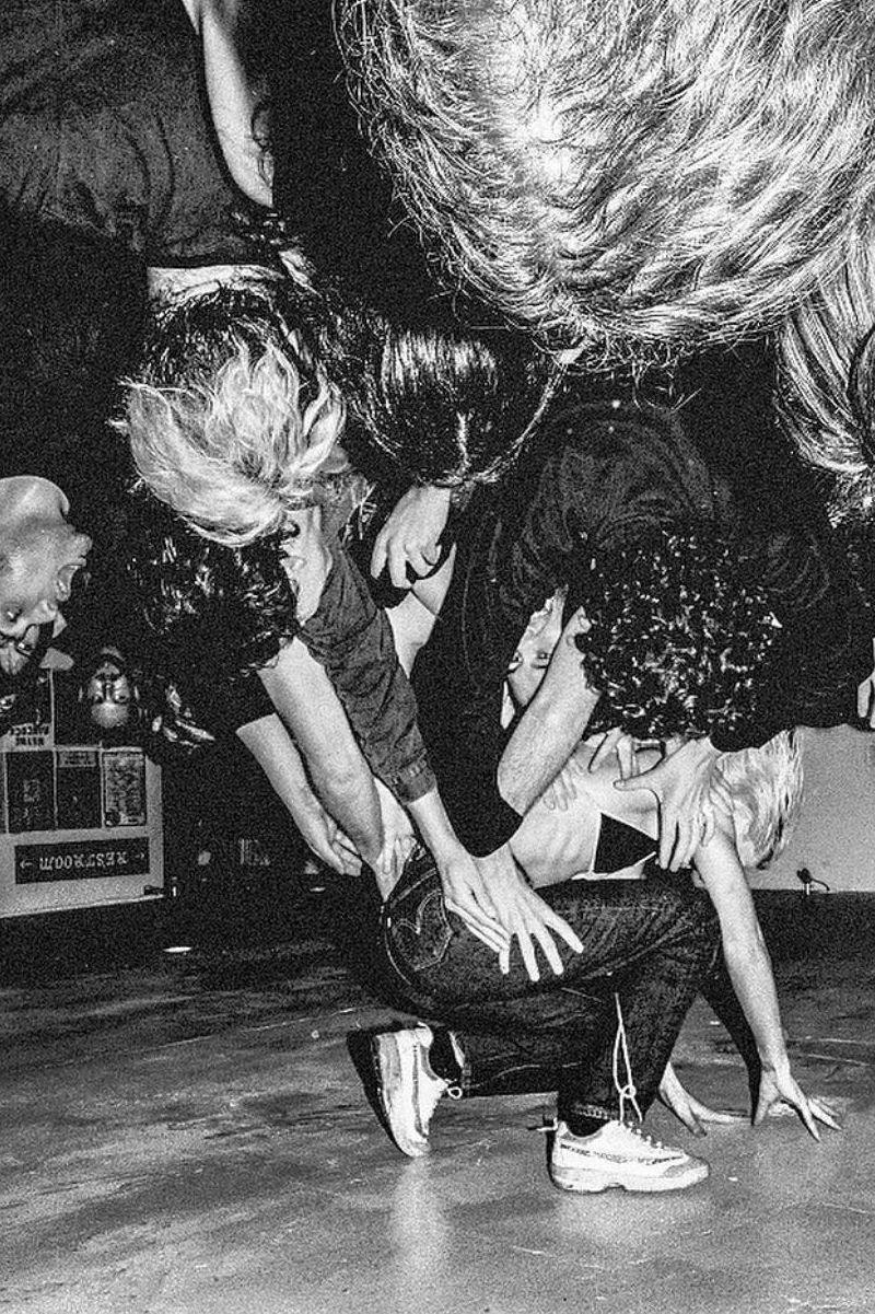 A black and white, upside down shot of Amyl and the Sniffers frontwoman Amy Taylor crowd surfing the very low ceilings of Soda Bar in San Diego in 2019