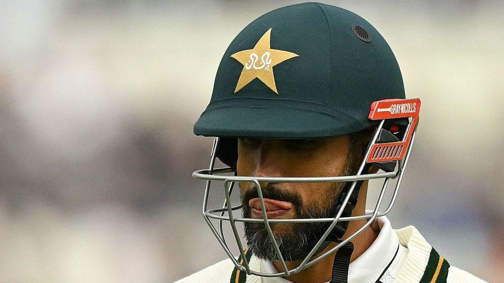 Shan Masood wipes his tongue across his top lip as he walks off after being dismissed during the Edgbaston Test