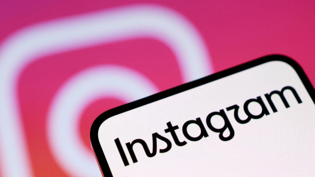 A phone screen with Instagram written on it. In the background is the pink and white Instagram camera logo
