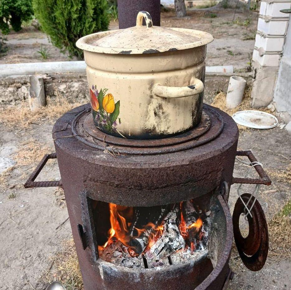 A cooking pot on a stove which has flames coming out of it