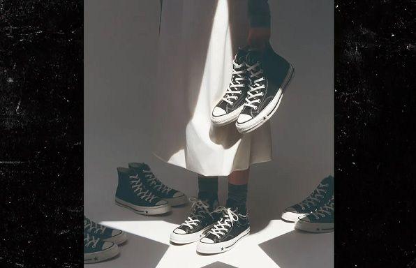 The photo from Converse's Instagram account which has since been deleted. A model in Converse trainers and a white skirt stands surrounded by other pairs of the trainers and holding a pair in her hand. A shadow on the floor casts the image of a star and there is a triangular shadow on her skirt.