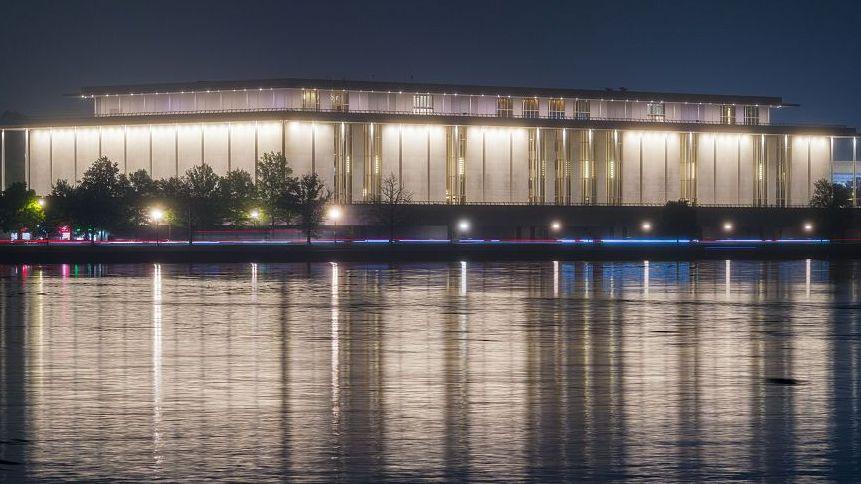 The Kennedy Center is seen lit up in the dark across the Potomac River in Washington DC