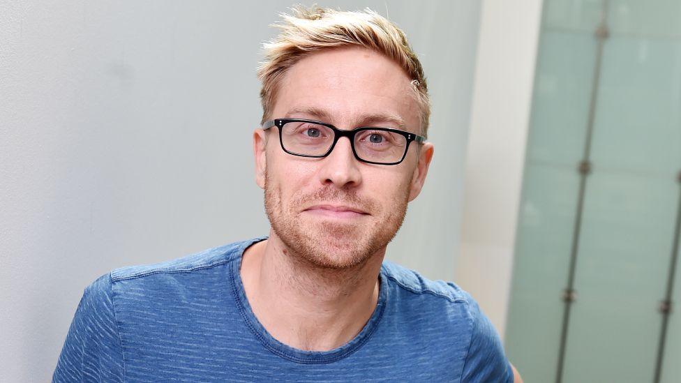 Russell Howard ‘devastated’ after his baby son died hours after birth Russell Howard pictured at the BBC's New Broadcasting House, wearing a blue T-shirt