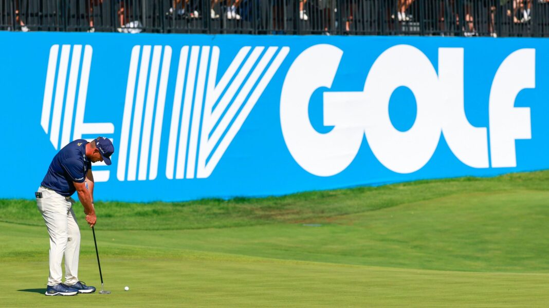 Golfer Bryson DeChambeau putts in front of a big blue and white LIV Golf sign