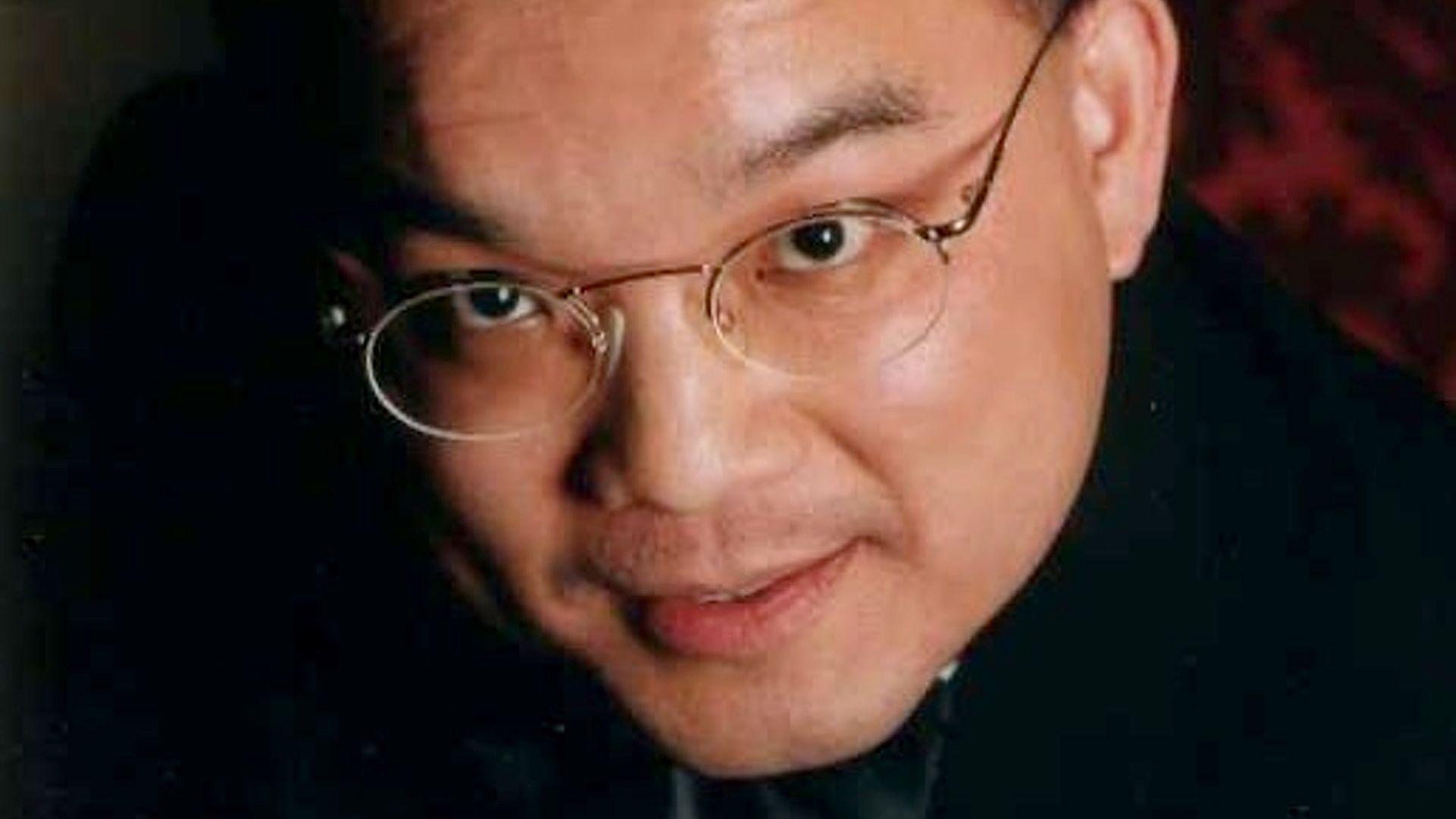 Close up of Kenneth Law, who is staring at the camera and is wearing glasses.