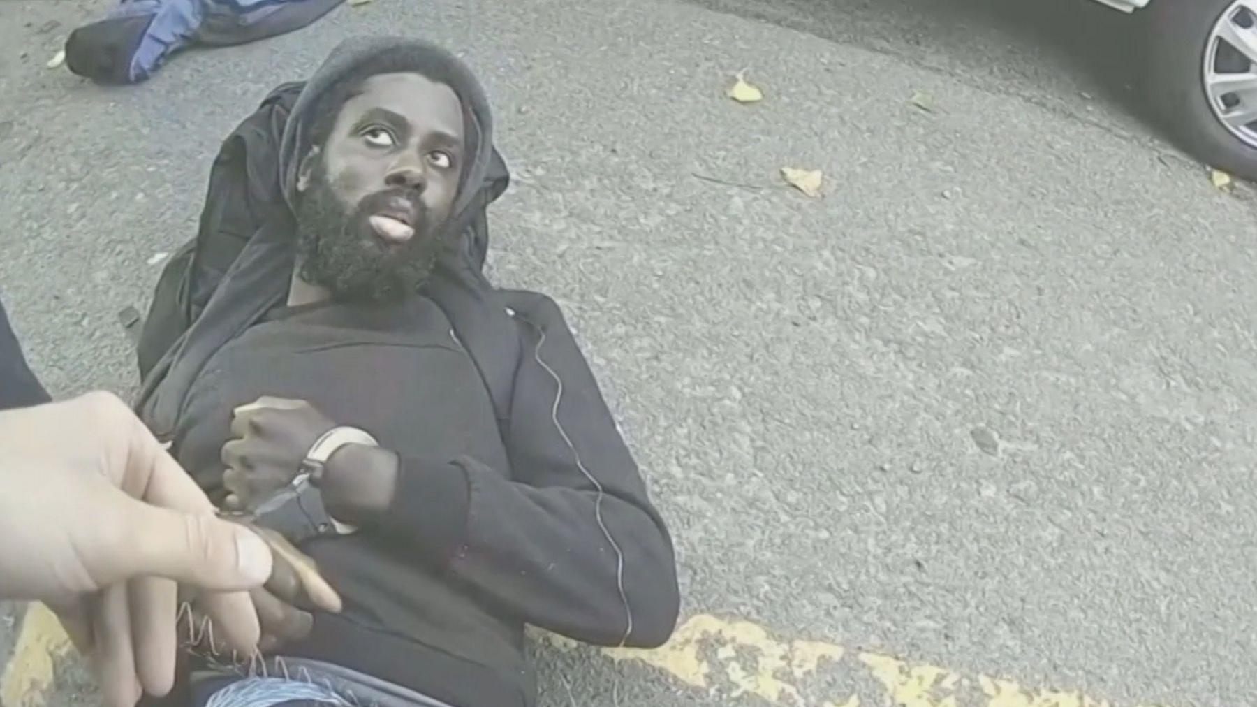 Valdo Calocane, the Nottingham attacks killer, being placed in handcuffs while laying in a road on 13 June 2023.