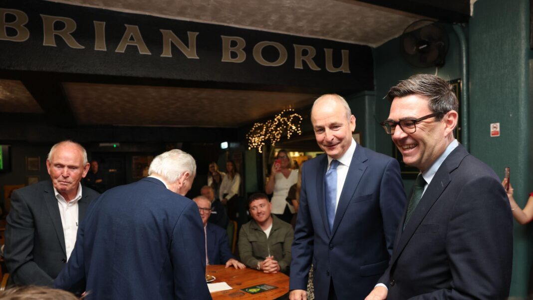 British Prime Minister Andy Burnham (R) and Irish Taoiseach Micheal Martin (C) visit the Brian Boru Irish Club in Ashton-in-Makerfield, Wigan, Greater Manchester.