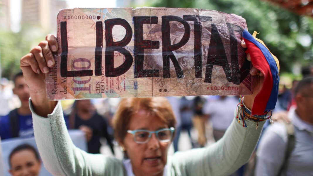 Venezuela releases dozens of political prisoners as election calls grow A woman holds a sign during a demonstration calling for the return of opposition leader Maria Corina Machado and free elections in Venezuela, in Caracas.