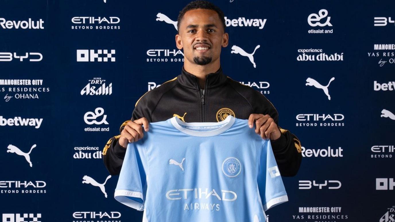 Iliman Ndiaye poses with Manchester City shirt after signing from Everton in a deal worth up to £65m